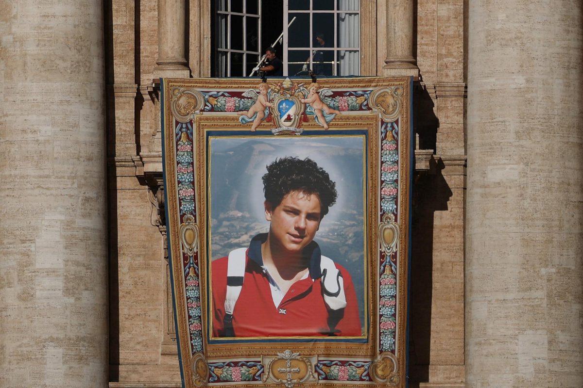 Workers install a tapestry on the facade of St. Peter's Basilica at the Vatican depicting an image of Carlo Acutis, a British-born Italian boy who will become the first millennial to be made a Catholic saint in a ceremony led by Pope Leo, as seen from Rome, Italy, September 4, 2025. REUTERS/Guglielmo Mangiapane